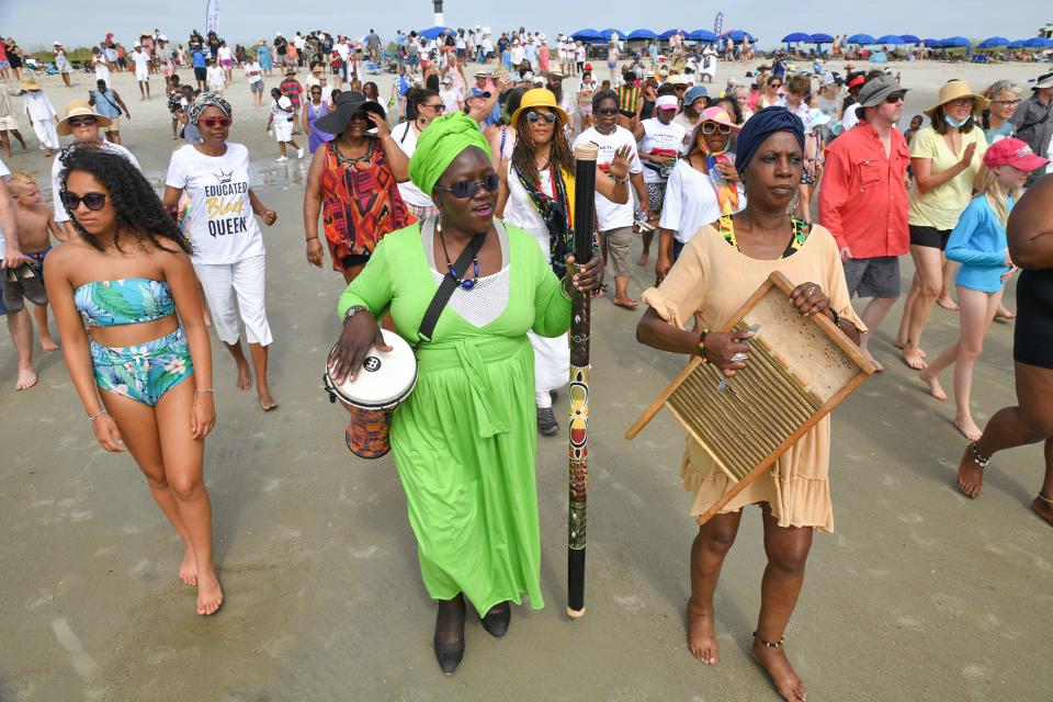 Patt Gunn, center, of the Gulah Geechee Saltwata Players leads participants into the waters of the Atlantic Ocean for Juneteenth Wade In during Tybee Island MLK Committee Juneteenth Celebration in 2021.