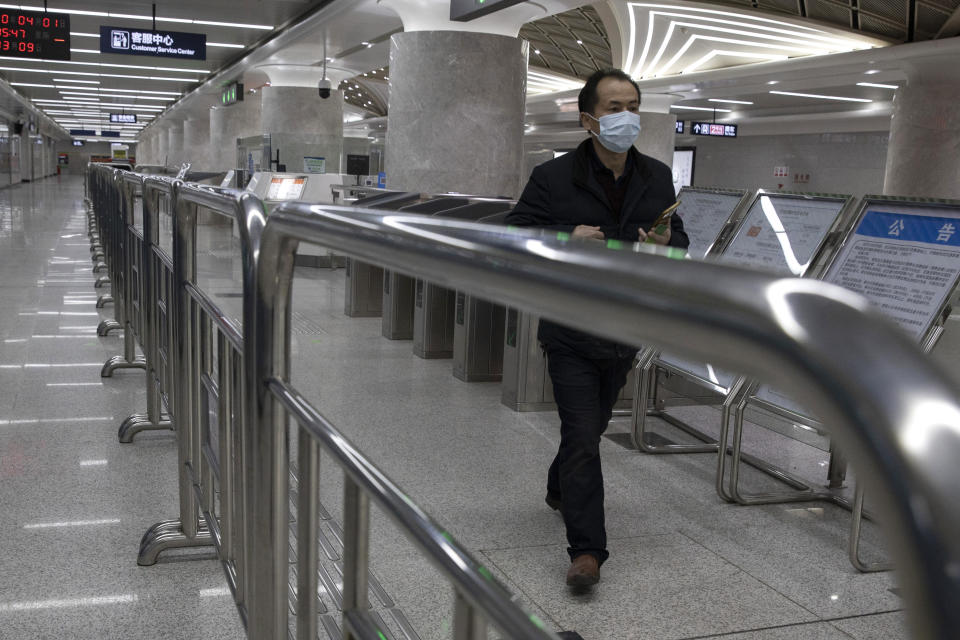 In this April 1, 2020, photo, a man walks through a subway station in Wuhan in central China's Hubei province. Life in China post-coronavirus outbreak is ruled by a green symbol on a smartphone screen. Green signifies the "health code" that says the user is symptom-free. It is required to board a subway, check into a hotel or enter Wuhan, the city where the global pandemic began. (AP Photo/Ng Han Guan)