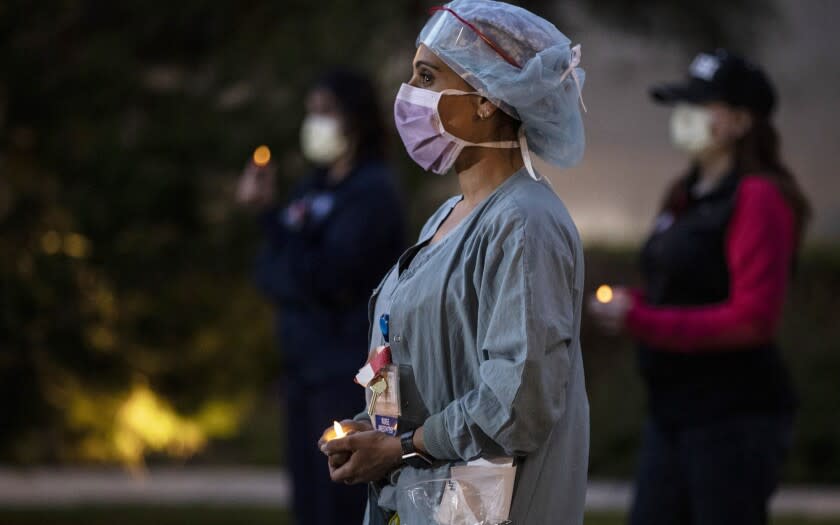 Nurse anesthetist Nilu Patel quietly stands with fellow nurses at UC Irvine Medical Center for an hour long candlelight vigil at their shift change. They describe conditions and the need for more N95 respirators and protective gear required to safely treat coronavirus patients. (Robert Gauthier / Los Angeles Times)