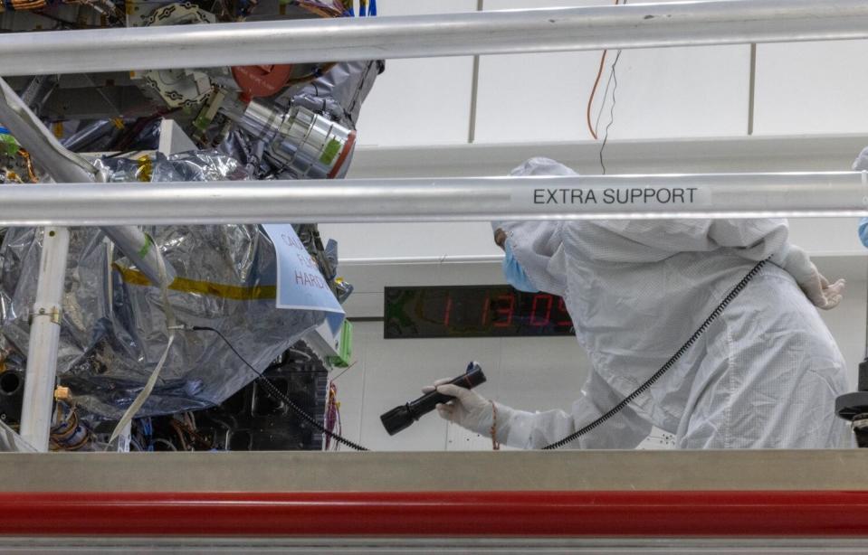 A JPL employee inspects the Europa Clipper spacecraft