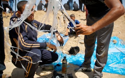 Palestinian protestors prepare an incendiary kite - Credit: MOHAMMED ABED/AFP/Getty Images