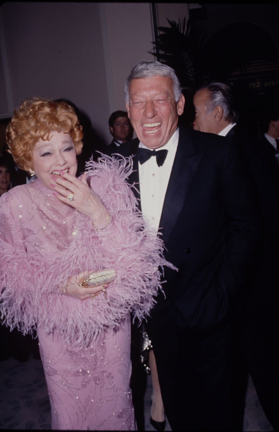 1980: Smiling alongside her husband Gary Morton, wearing a delightfully feathery gown.