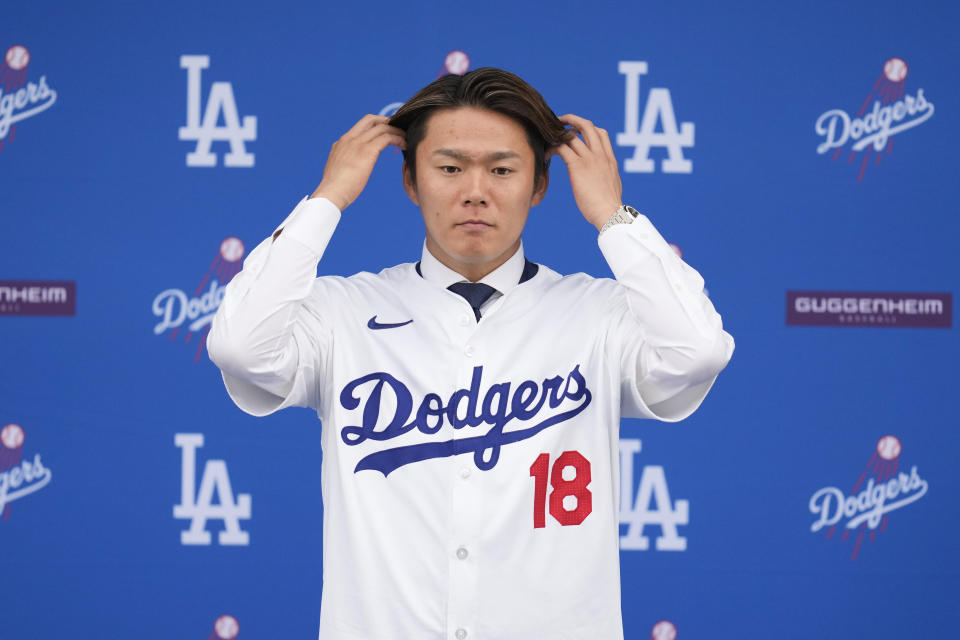 Yoshinobu Yamamoto stands on the stage during his introduction as a new member of the Los Angeles Dodgers baseball team Wednesday, Dec. 27, 2023, in Los Angeles. (AP Photo/Ashley Landis)