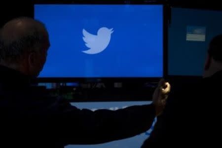 An employee adjusts a screen that displays the Twitter logo ahead of the company's IPO on the floor of the New York Stock Exchange, in this file picture taken November 6, 2013. REUTERS/Brendan McDermid/Files