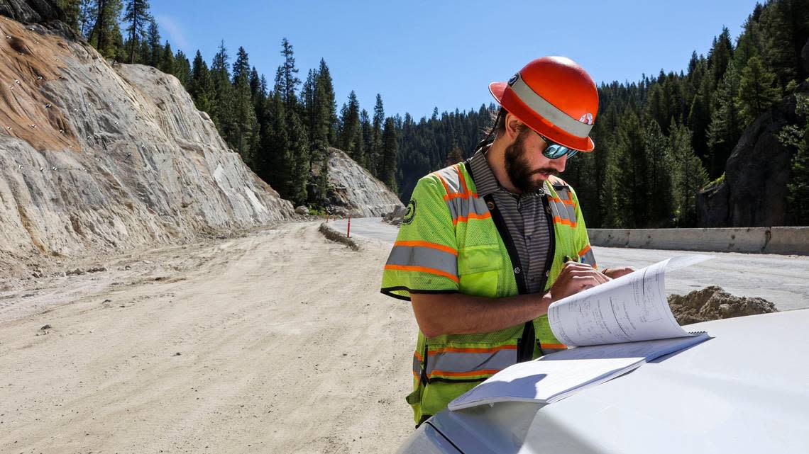 Alex Deduck, Idaho Transportation Department project manager, thumbs through a stack of design and construction plans for the mile-long stretch of Idaho 55 north of Smiths Ferry.