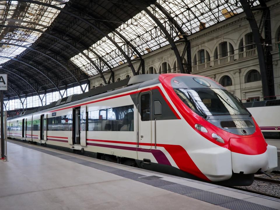 A red and white train in a train station in Barcelona, Spain
