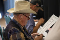 Paul Klopfer reads his ballot while voting at a polling center in the South Valley area of Albuquerque, N.M., Tuesday, Nov. 8, 2022 (AP Photo/Andres Leighton)