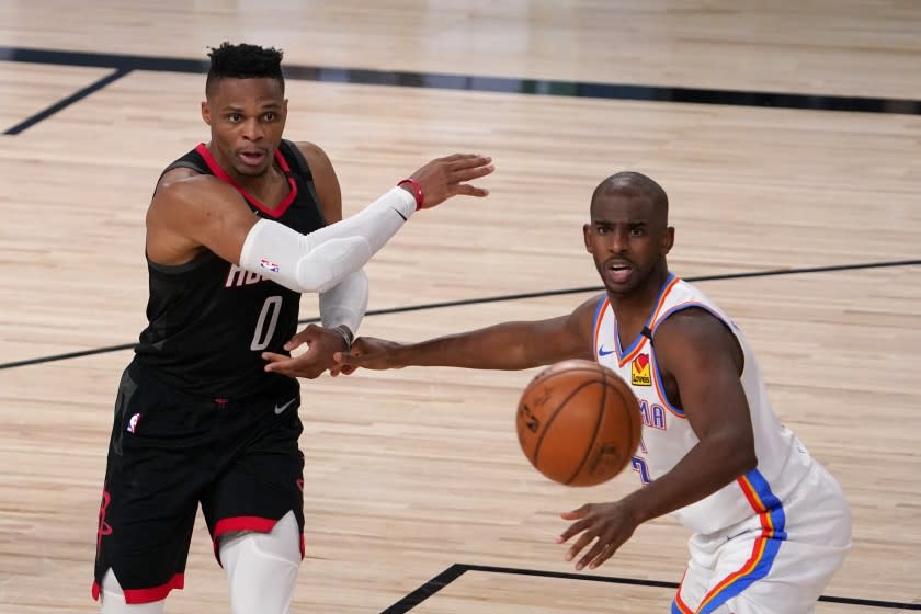 Houston Rockets' Russell Westbrook (0) makes a pass under pressure from Oklahoma City Thunder's Chris Paul, right, during the second half of an NBA first-round playoff basketball game in Lake Buena Vista, Fla., Wednesday, Sept. 2, 2020. (AP Photo/Mark J. Terrill)