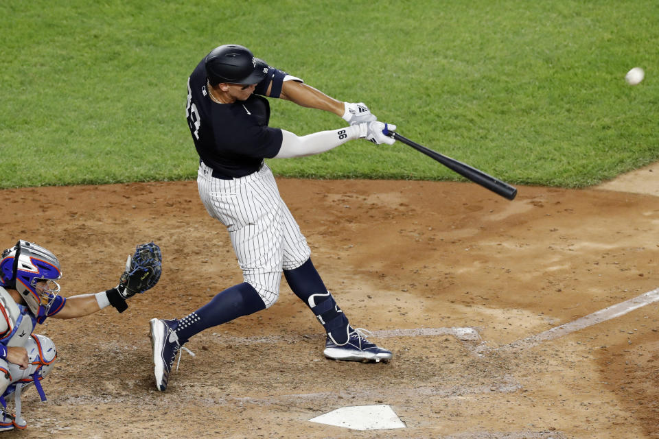New York Yankees Aaron Judge hits a two-run, home run during the sixth inning of an exhibition baseball game against the New York Mets, Sunday, July 19, 2020, at Yankee Stadium in New York. Mets catcher Rene Rivera (44) is behind the plate. It was Judge's second home run of the game. (AP Photo/Kathy Willens)