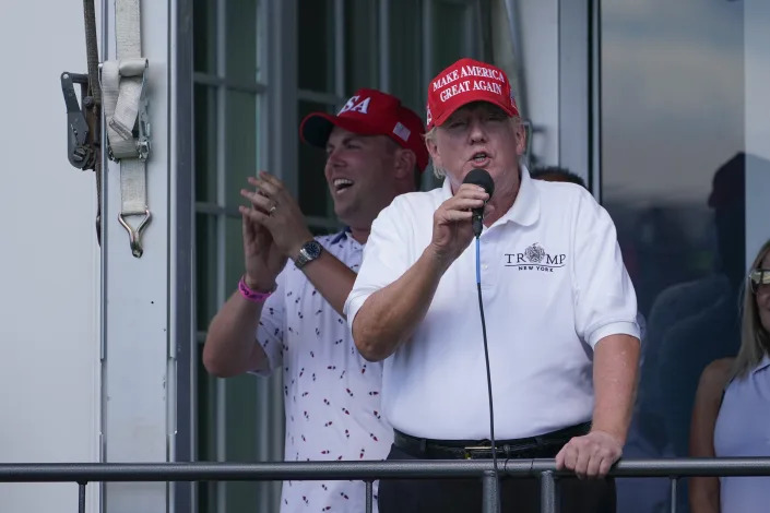 Former President Donald Trump holds a microphone as he speaks.