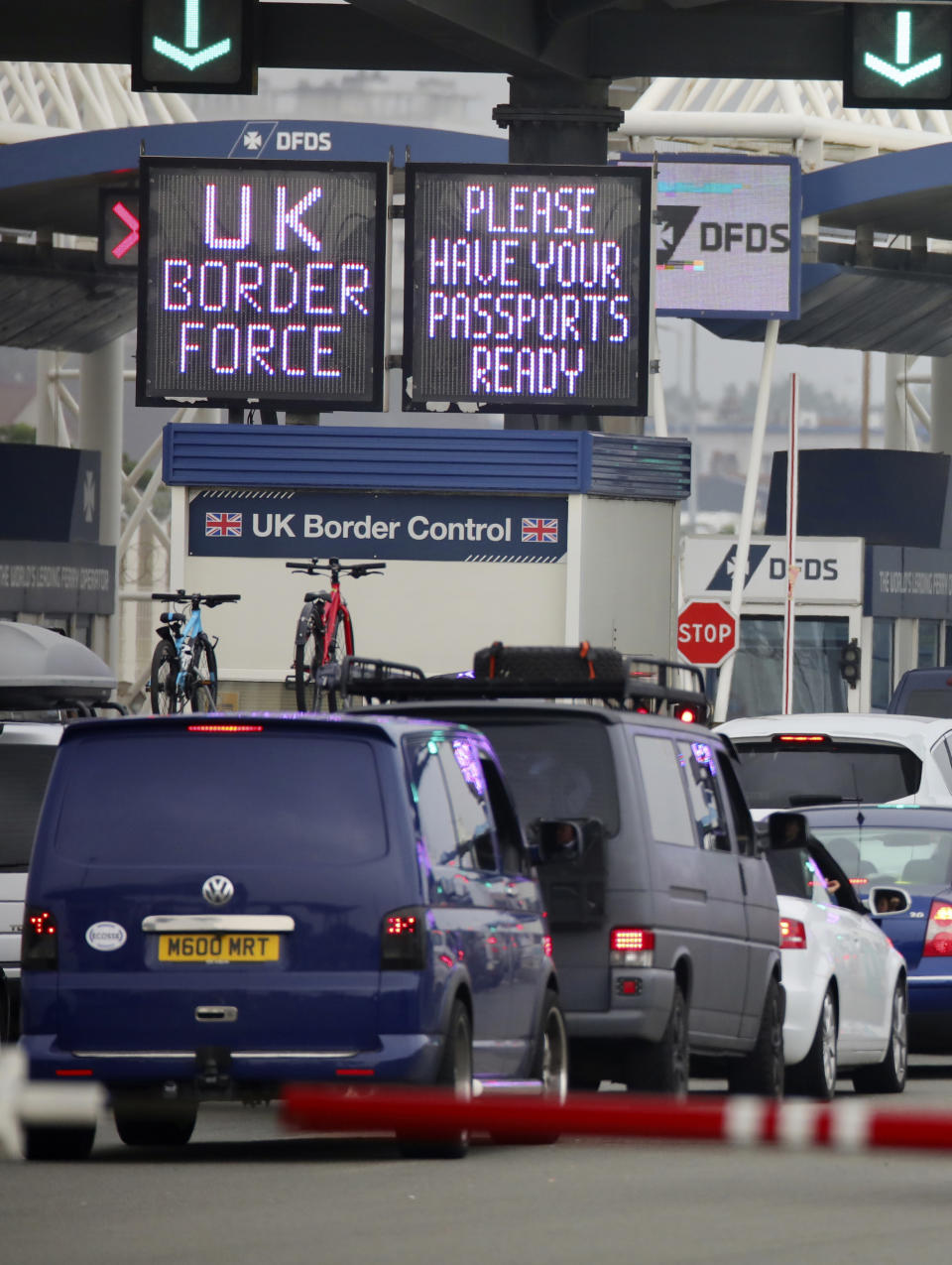 People queue in line to check-in for the cross channel ferry in Calais, France, Friday Aug.14, 2020. British holiday makers in France were mulling whether to return home early Friday to avoid having to self-isolate for 14 days following the U.K. government's decision to reimpose quarantine restrictions on France amid a recent pick-up in coronavirus infections. (AP Photo/Olivier Matthys)