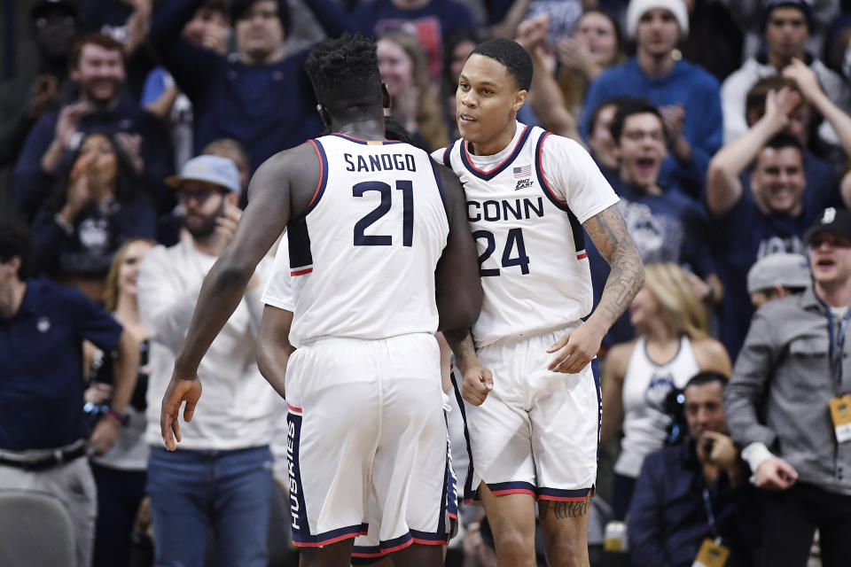 Connecticut's Adama Sanogo (21) and Jordan Hawkins (24) celebrate in the second half of an NCAA college basketball game against UNC Wilmington, Friday, Nov. 18, 2022, in Storrs, Conn. (AP Photo/Jessica Hill)