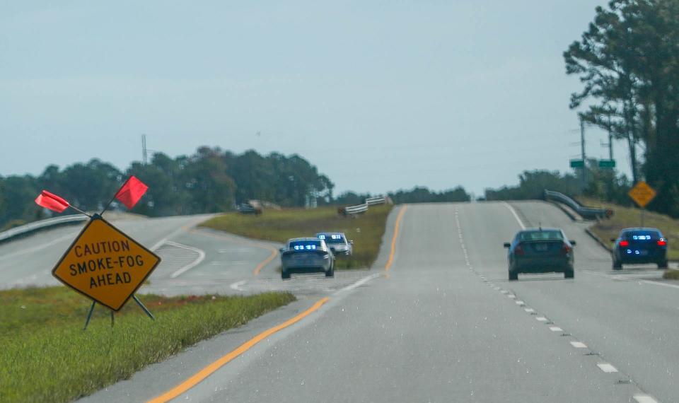 Signs warn of smoke ahead as police sit at the entrance to Satilla Shores on Monday November 7, 2022 following an explosion and fire at the Symrise chemical plant in Brunswick Georgia.