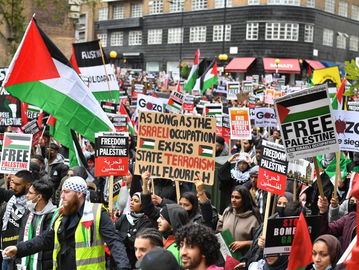 <p>Pro-Palestinian demonstrators walk through Kensington towards  the Israeli embassy in London</p> (PA)