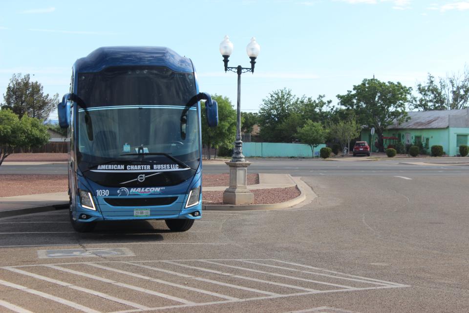 An idling state-run charter bus waits for U.S. Border Patrol to drop migrants off at the Douglas Visitor's Center parking lot on Wednesday, May 17, 2023.