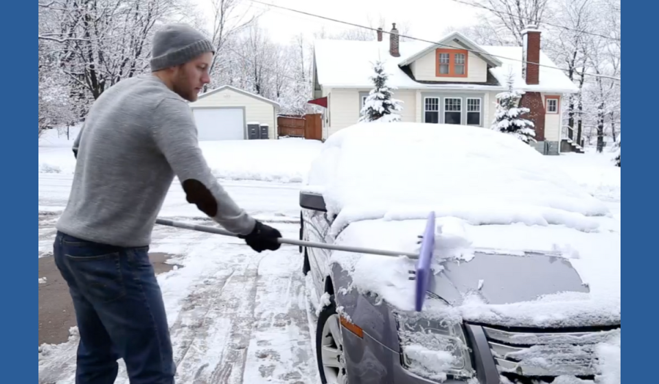 man removing snow from his car