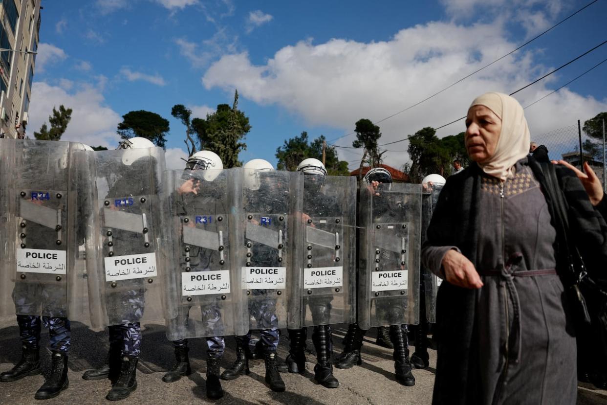 Riot police officers stand guard while Palestinians protest against U.S. Secretary of State Antony Blinken's visit and his meeting with Palestinian President Mahmoud Abbas in Ramallah on Jan. 10, 2024. (REUTERS - image credit)