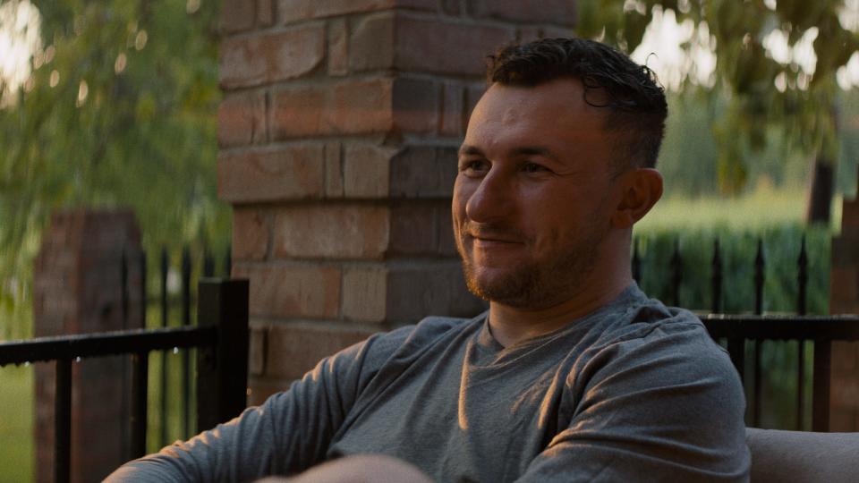 Johnny Manziel sits on a porch at sunset.