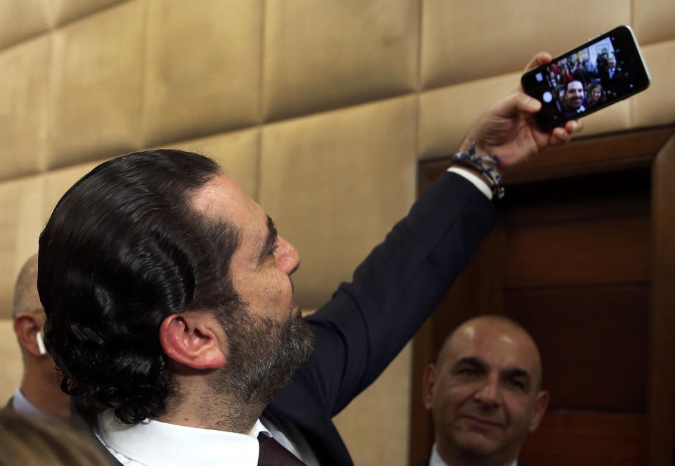 Newly-assigned Lebanese Prime Minister Saad Hariri, takes a selfie with reporters after he announced his new cabinet, at the presidential palace in Baabda, east of Beirut, Lebanon, Thursday, Jan. 31, 2019. Lebanese political factions have agreed on the formation of a new government, breaking a nine-month deadlock that only deepened the country' economic woes. (AP Photo/Hussein Malla)