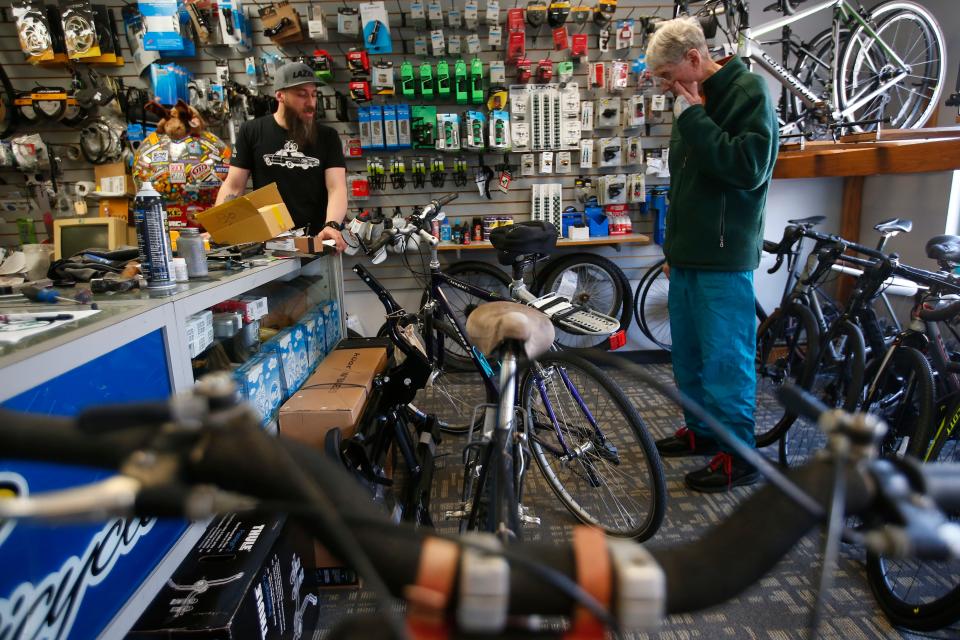 Kevin Rodrigues, manager, discusses the items David Bourne will need to change on his bicycle after bring it in for a tune-up at Scottee's Westport Bicycle on Route 6 in Westport.