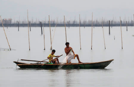 Fishermen recover nets at their fishpens in Laguna de Bay, before Typhoon Mangkhut hits the main island of Luzon, in Muntinlupa, Metro Manila, in Philippines, September 14, 2018. REUTERS/Erik De Castro