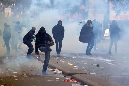 Tear gas floats around masked protesters during clashes with French CRS riot police at the May Day labour union rally in Paris, France May 1, 2018. REUTERS/Philippe Wojazer