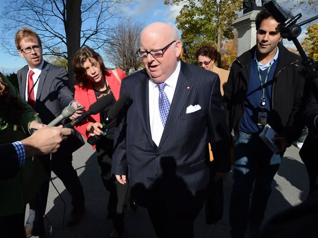 Sen. Mike Duffy is questioned by media as he arrives at the Senate on Parliament Hill in Ottawa on Tuesday, Oct. 22, 2013. THE CANADIAN PRESS/Sean Kilpatrick