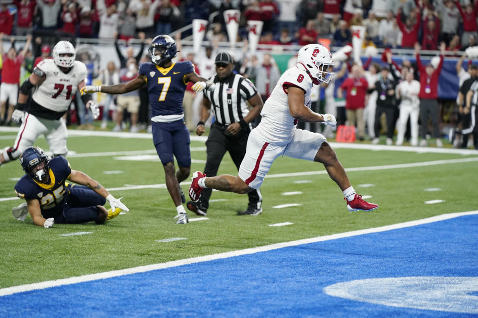 Miami (Ohio) running back Rashad Amos (0) breaks through the Toledo defense for a 10-yard rushing touchdown during the second half of the Mid-American Conference championship NCAA college football game, Saturday, Dec. 2, 2023, in Detroit. (AP Photo/Carlos Osorio)