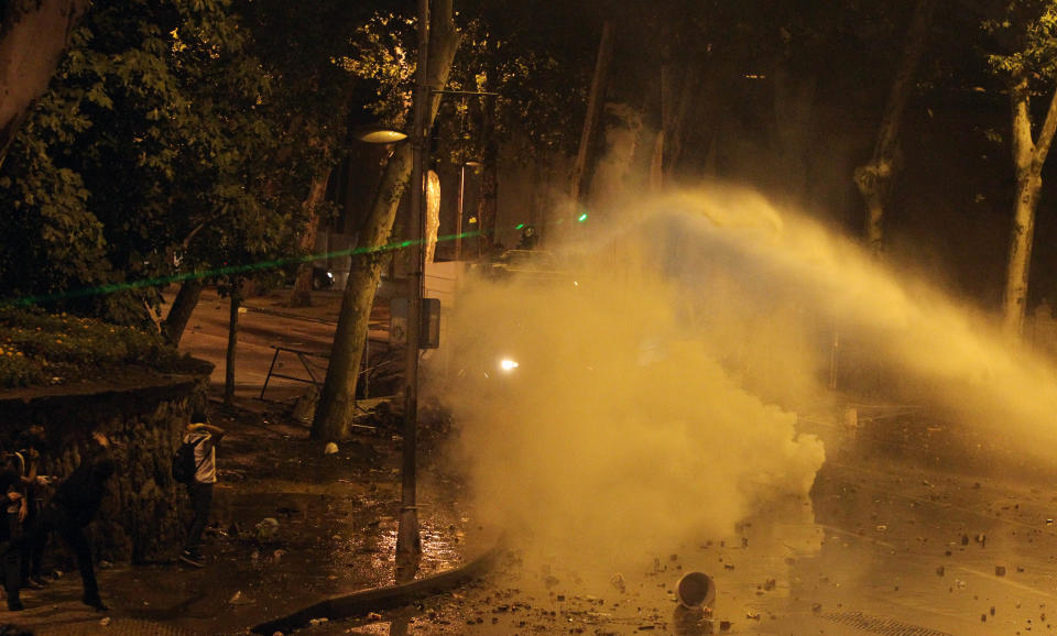 Police use a water cannon and tear gas as protesters light the area with a green laser light during the third day of nationwide anti-government protest near the Prime Minister's office at Besiktas area in Istanbul, late Sunday, June 2, 2013. Protests in Istanbul and several other Turkish cities appear to have subsided, after days of fierce clashes following a police crackdown on a peaceful gathering. The demonstrations grew out of anger over a violent police crackdown of a peaceful environmental protest at Istanbul's Taksim Square and spread to other Turkish cities. (AP Photo/Thanassis Stavrakis)