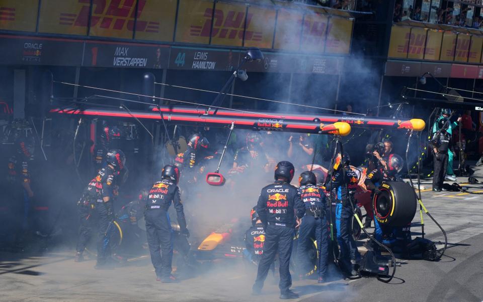 Mechanics deal with the smoke coming out of Red Bull Racing's Dutch driver Max Verstappen car during the Australian Formula One Grand Prix