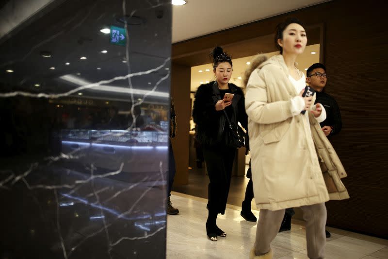 FILE PHOTO: Chinese tourists shop at a Lotte duty free shop in central Seoul