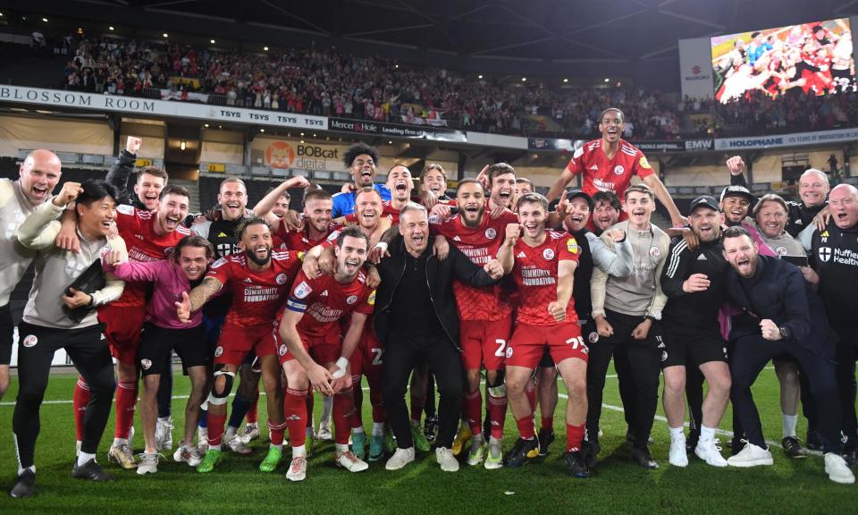 <span>Crawley’s manager, Scott Lindsey (centre), celebrates with players and staff in front of the fans after winning the League Two playoff semi-final against MK Dons.</span><span>Photograph: Harriet Lander/Getty Images</span>