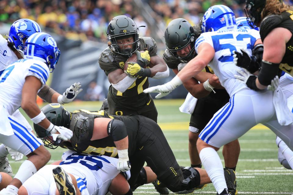 Oregon's Noah Whittington, center, rushes against BYU during the second half Saturday, Sept. 17, 2022.