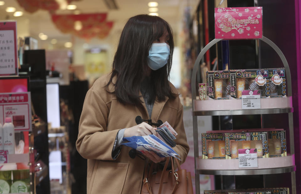 A woman purchases a supply of disposable face masks at a cosmetics shop in Hong Kong, Saturday, Feb, 1, 2020. China has moved to lock down at least three big cities in an unprecedented effort to contain the deadly new virus that has sickened hundreds of people and spread to other parts of the world. (AP Photo/Achmad Ibrahim)