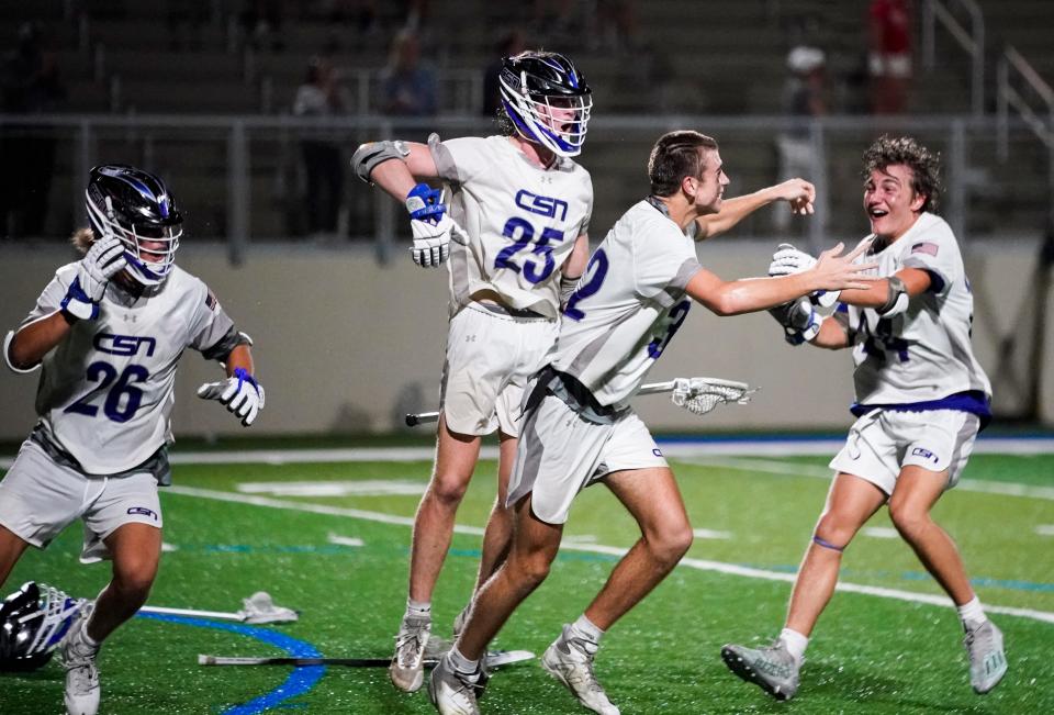 Community School of Naples Seahawks players celebrate after defeating the Cardinal Mooney Cougars 13-12 in the Class 1A Region 3 semifinal at Community School of Naples on Wednesday, April 26, 2023.