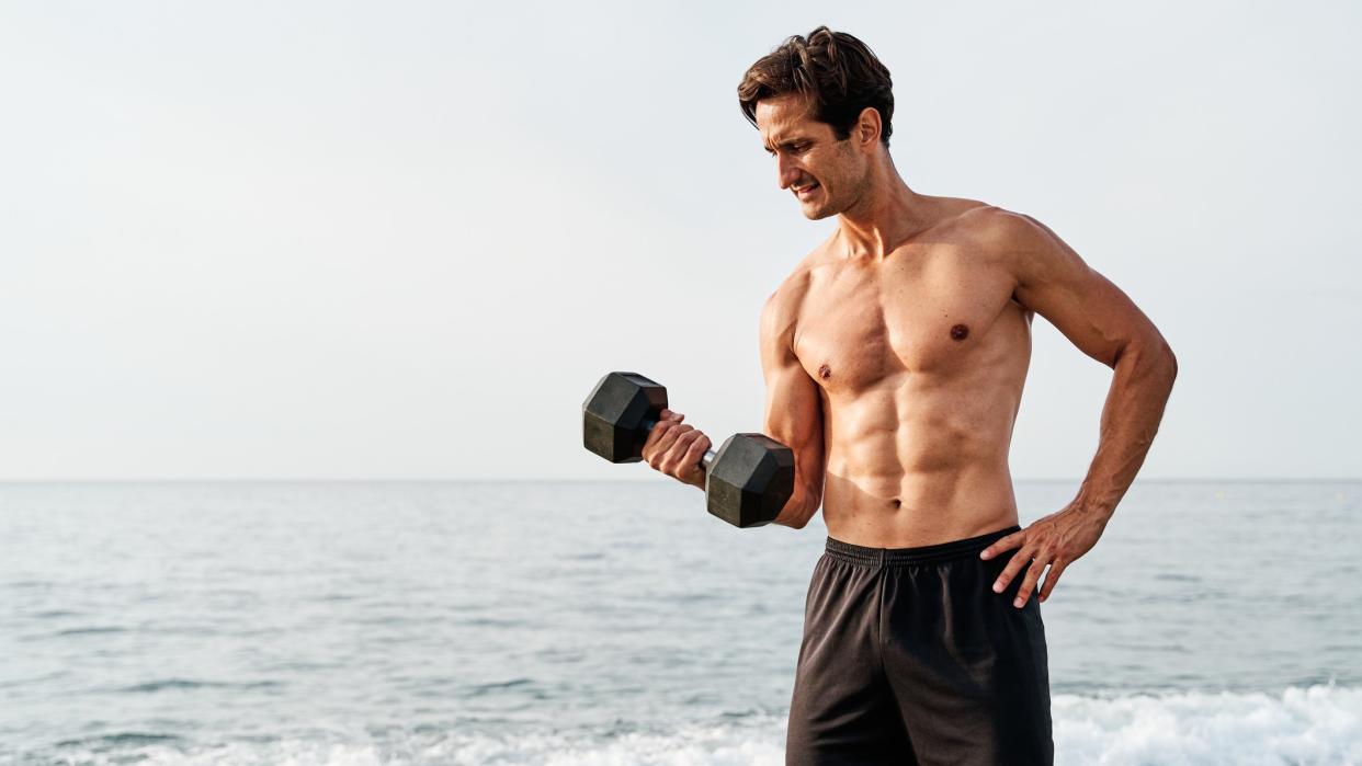  a photo of a man holding a dumbell 