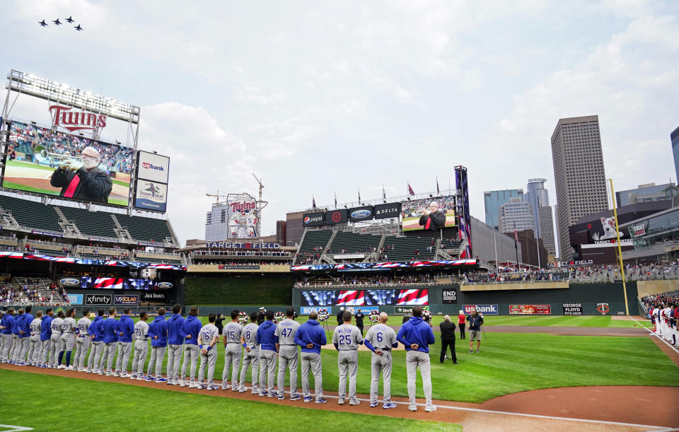 Four fighter jets, upper left, fly over Target Field where players from the Minnesota Twins and the Kansas City Royals observed a moment of silence to mark the 20th anniversary of 9/11 prior to the their baseball game Saturday, Sept. 11, 2021, in Minneapolis. (AP Photo/Jim Mone)