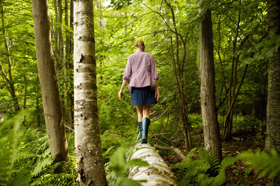 Frau spaziert alleine im Wald