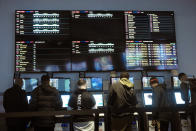 In this Nov. 18, 2019 photo, patrons visit a betting kiosk in the sports betting area of Twin River Casino in Lincoln, R.I. Legalized sports betting's rapid march across the U.S. could face some bigger tests in 2020. Less than two years after a U.S. Supreme Court ruling opened the door to sportsbooks outside Nevada, they have been legalized in states that are home to about one-third of the nation's population. (AP Photo/Steven Senne)