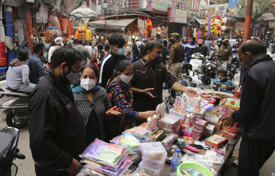 Indians wearing face masks as a precautionary measure against the coronavirus crowd a market during Diwali, the Hindu festival of lights, in Jammu, India, Saturday, Nov. 14, 2020. (AP Photo/ Channi Anand)