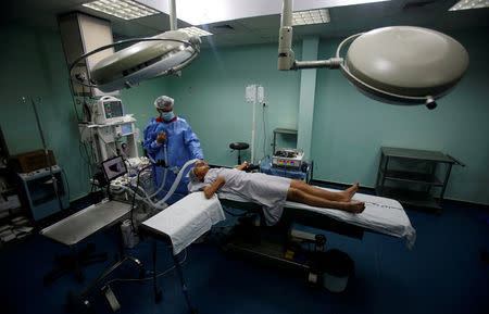 A doctor anaesthetises a patient before the start of a Proximie surgery, with doctor Ghassan Abu Sitta in Beirut guiding Palestinian surgeon Hafez Abu Khousa, in the operating room at Al Awda Hospital in the northern Gaza Strip April 30, 2016. REUTERS/Suhaib Salem