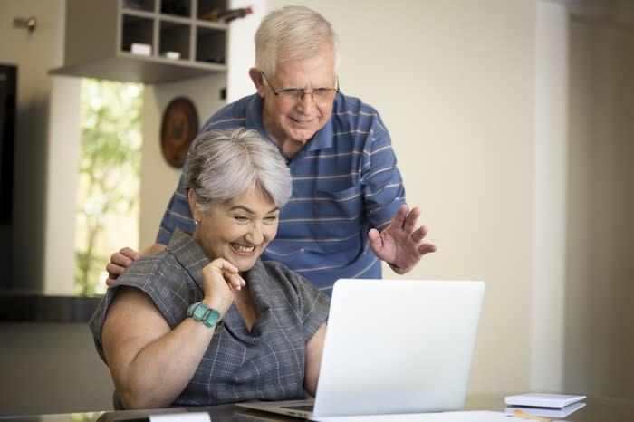 Smiling older couple looking at a laptop