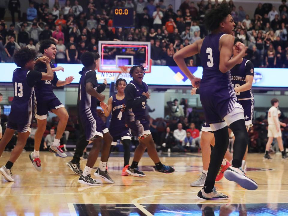 New Rochelle players celebrate their 52-50 overtime victory over Mamaroneck in the Section 1 Class AAA semifinal at the Westchester County Center in White Plains Feb. 28, 2024.