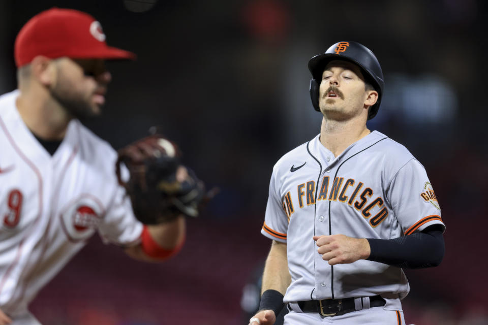 San Francisco Giants' Mike Yastrzemski, right, reacts as he is caught in a double play while attempting to return to first base during the sixth inning of a baseball game against the Cincinnati Reds in Cincinnati, Friday, May 27, 2022. (AP Photo/Aaron Doster)