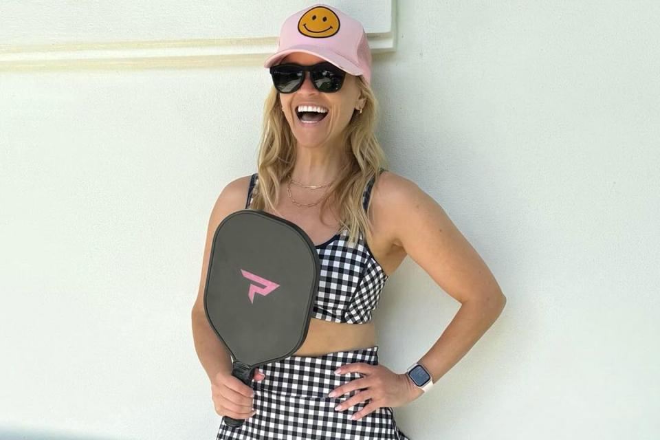 <p>Reese Witherspoon/Instagram</p> Reese Witherspoon takes on pickleball in flirt gingham skort and sports bra