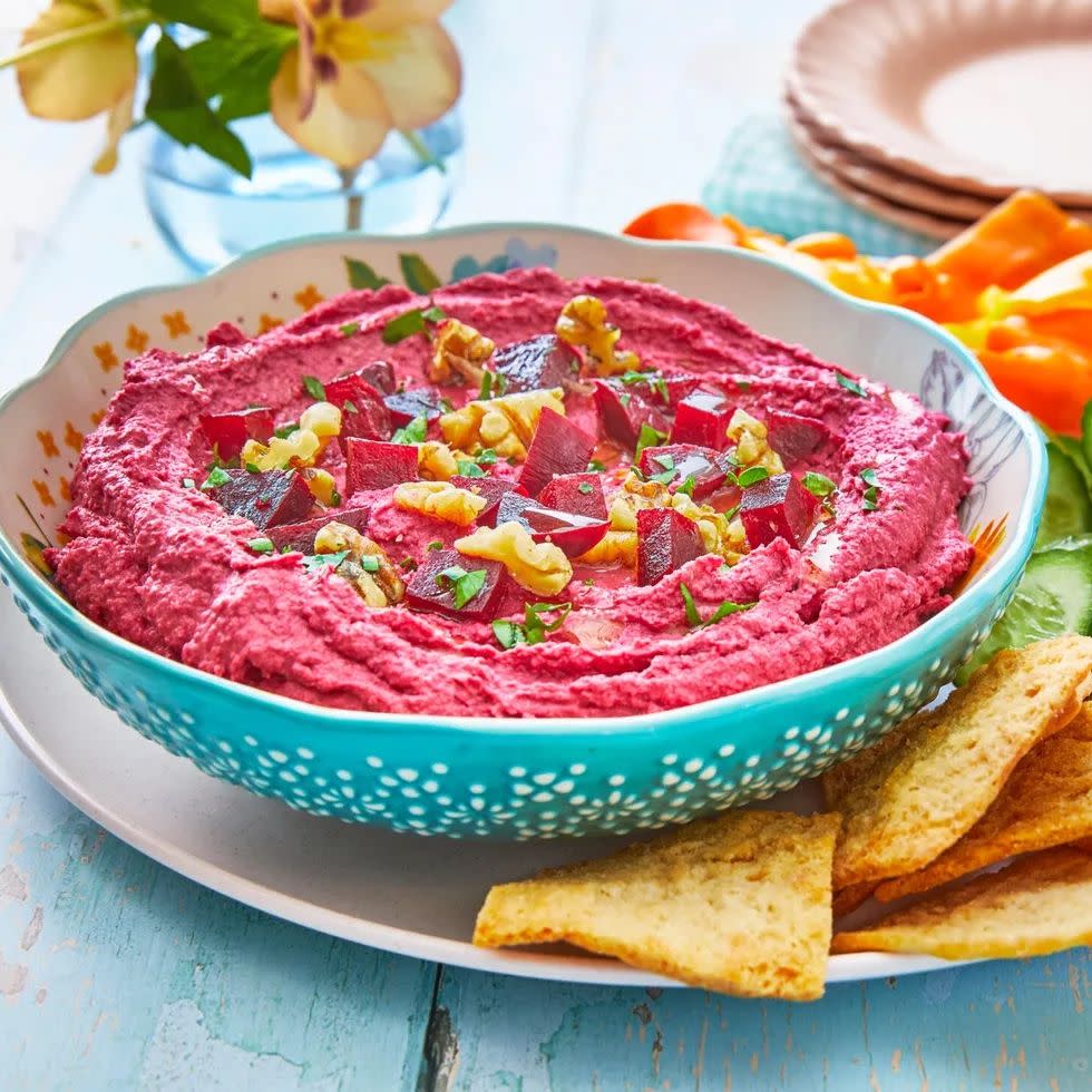 beet hummus with pita chips in blue bowl