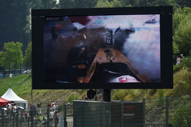 A big screen shows the crash of Renault driver Kevin Magnussen during the Belgian Grand Prix in Spa on August 28, 2016