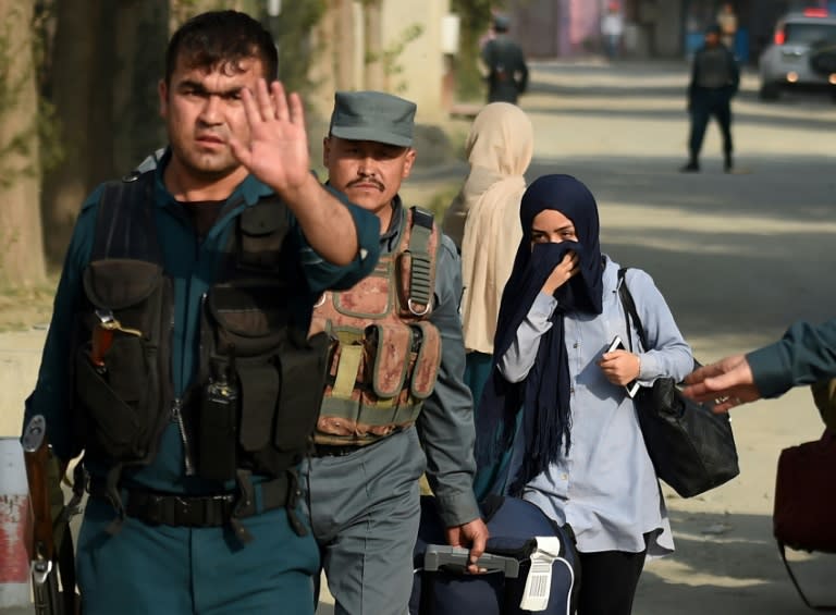 Afghan women students, who were trapped inside the American University of Afghanistan in Kabul during an attack by militants, are escorted by police after a nearly 10-hour raid on August 25, 2016