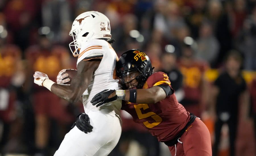 Iowa State defensive back Myles Purchase (5) tackles Texas running back CJ Baxter (4) during the first half of an NCAA college football game, Saturday, Nov. 18, 2023, in Ames, Iowa. (AP Photo/Matthew Putney)