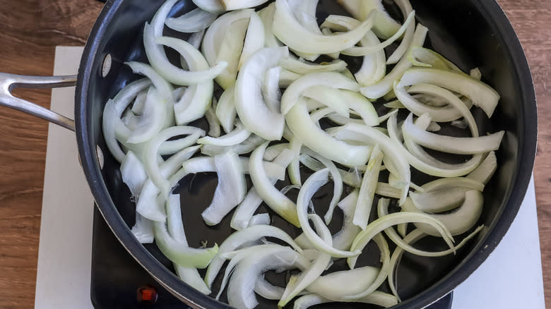 uncooked sliced onions in a pan